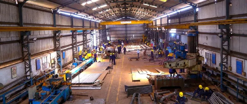 Manufacturing shop floor with overhead cranes and fabricated components